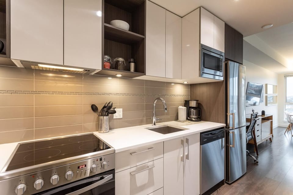 Modern kitchen equipped with full-sized stainless steel appliances, electric range, and built-in microwave.