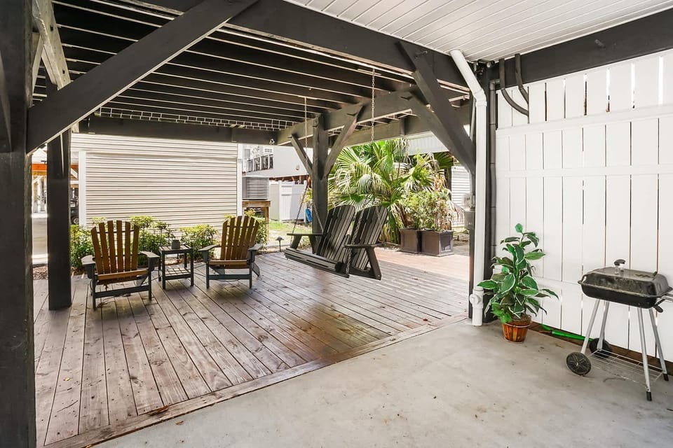 Spacious covered patio with cozy seating and lush greenery