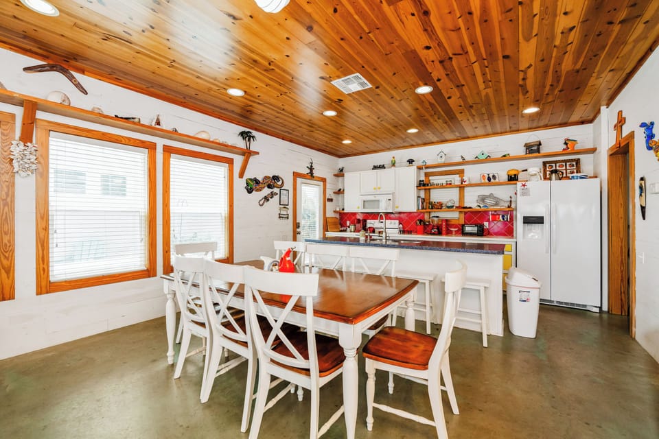 The dining table seats 8 guests with room for more at the breakfast bar