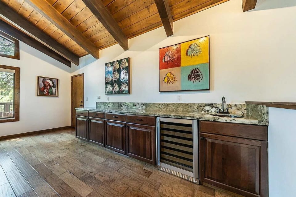 Living Room: Plush furnishings, 55” Smart TV, gas fireplace, wet bar with wine cooler and sink, soaring windows 
