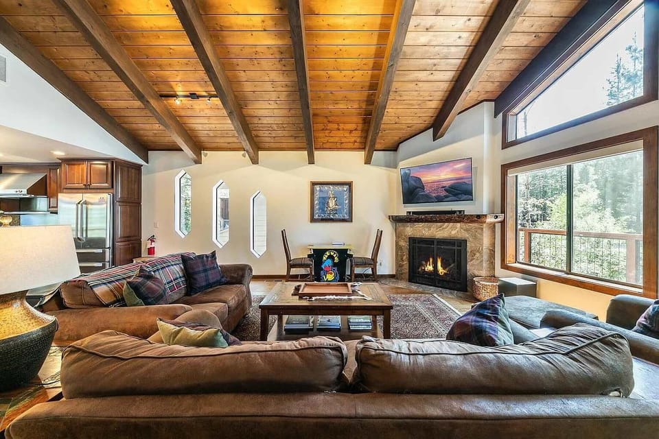 Living Room: Plush furnishings, 55” Smart TV, gas fireplace, wet bar with wine cooler and sink, soaring windows 
