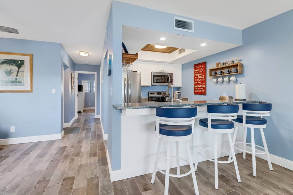 An eating bar with 3 bar stools separates the kitchen from the main living space.