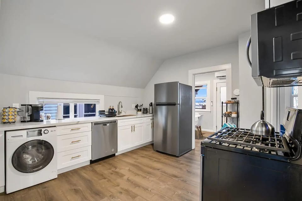 Spacious kitchen featuring a washer, dishwasher, and ample countertop space for cooking and meal preparation.
