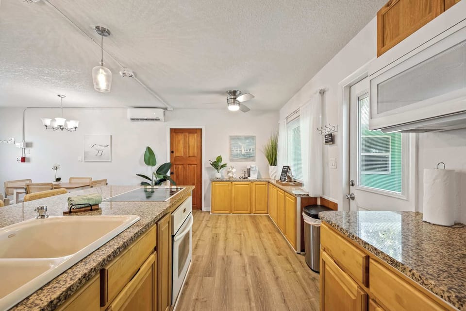 Spacious kitchen with granite countertops and natural wood cabinetry.