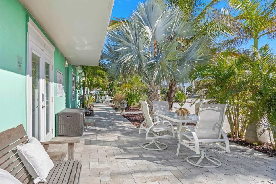 Relax in the shaded outdoor patio surrounded by tropical palm trees.