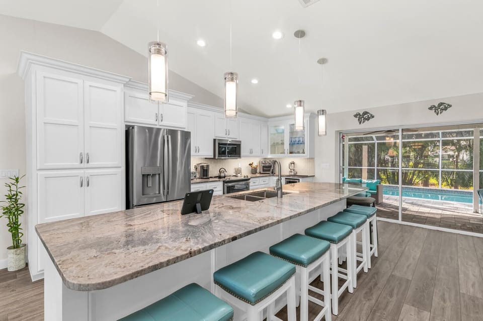 Large granite island w/ seating for 8. Bright, beautiful flow from house to pool