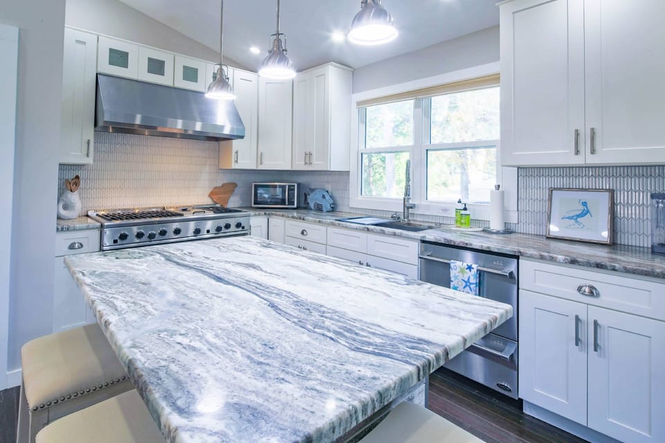 The kitchen features a beautifully-tiled backsplash as well as gas range with hood, dishwasher & microwave.