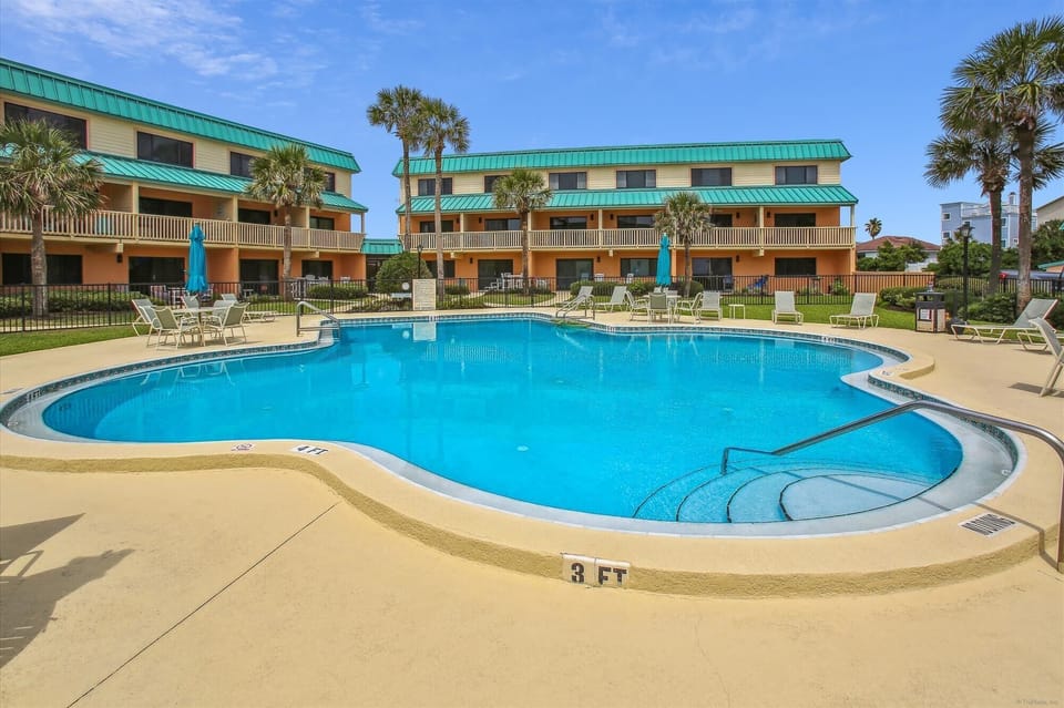 - Sparkling outdoor pool with shallow entry and palm tree views  
- Surrounded by lounge chairs and umbrellas for relaxing afternoons  
- Perfect spot to swim, sunbathe, and enjoy the Florida sunshine
