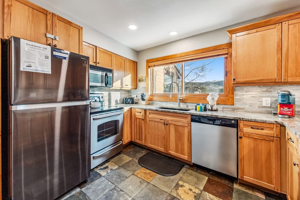 Kitchen is fully stocked with cookware/pots/pans and small appliances.