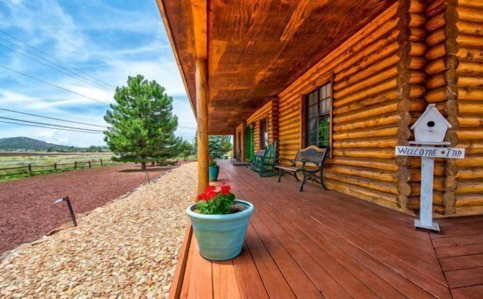 It features a King bed, a Victorian claw-foot tub, a fireplace in both the room and lobby, and private access to a wrap-around deck with stunning views of Bill Williams Mountain.
