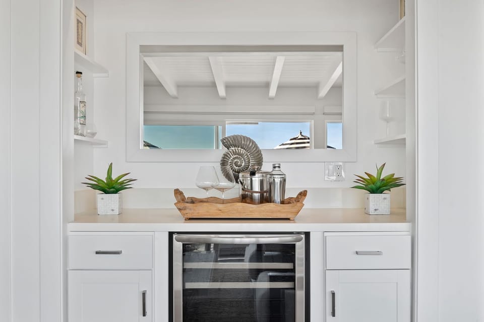 Upper: Built-in bar area features wine fridge and plenty of glassware