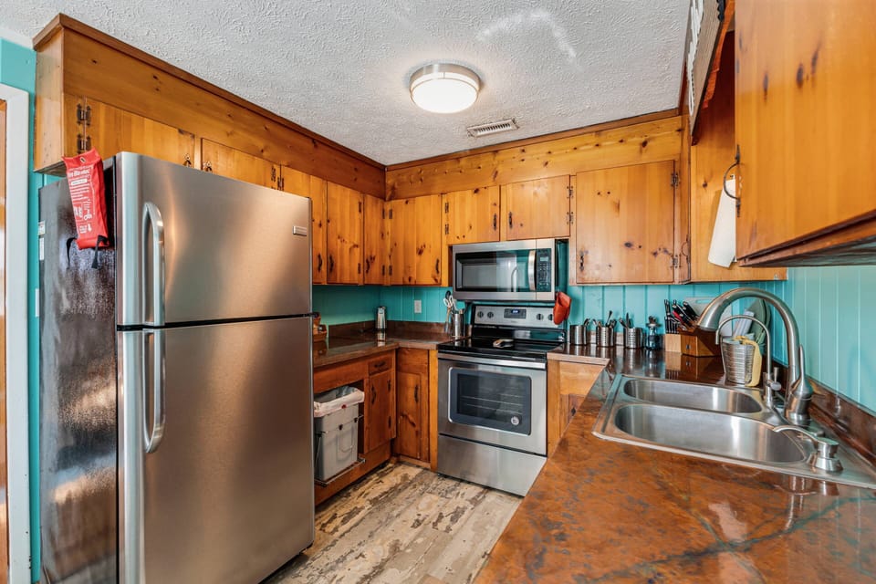 Kitchen with stainless-steel appliances. Features a spacious countertop, perfect for cooking.