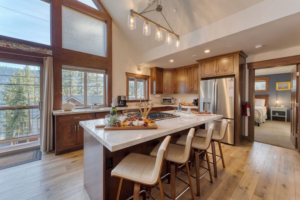 Kitchen features an island with barstool seating.