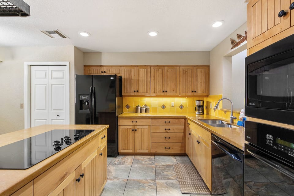 Kitchen comes equipped with sleek black appliances