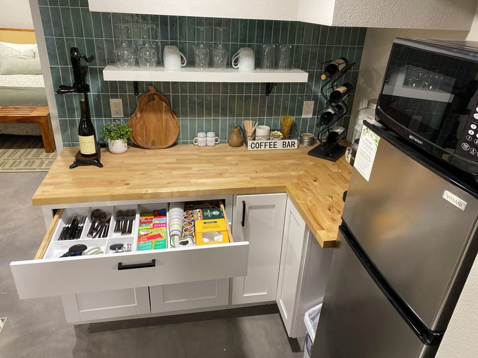 Refrigerator, microwave, toaster oven, water dispenser, coffee/tea. No sink.