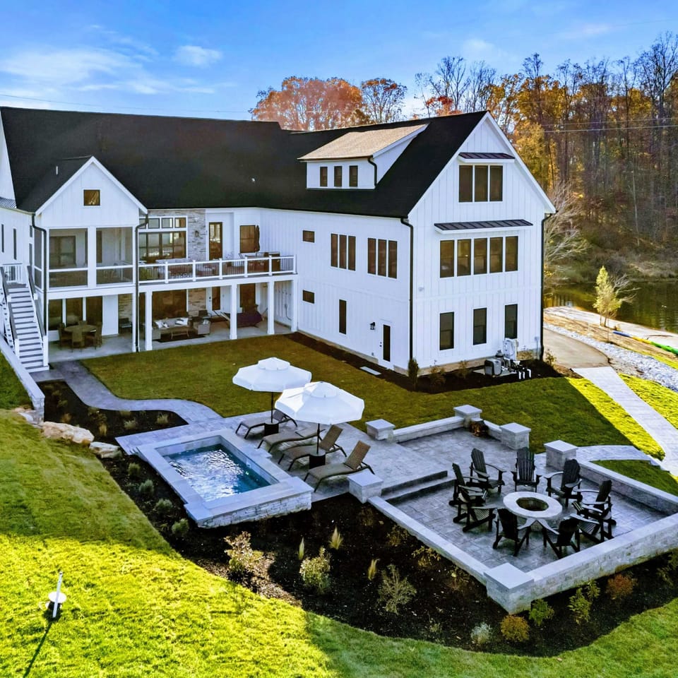 Backyard - Terraced outdoor living with a firepit circle, covered patio, and waterfront access.