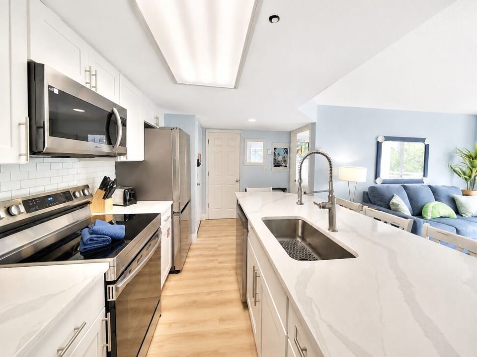 Enjoy cooking and gathering in the bright, fully equipped kitchen with stainless steel appliances, plenty of counter space, and an oversized island that opens to the living room.