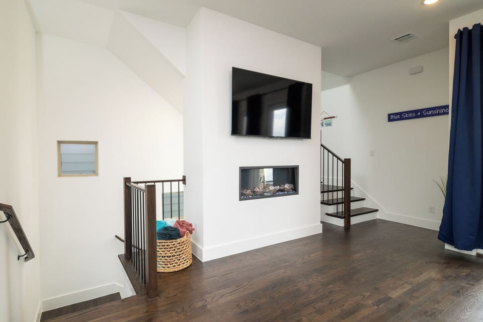 Living room has a large smart tv and fireplace