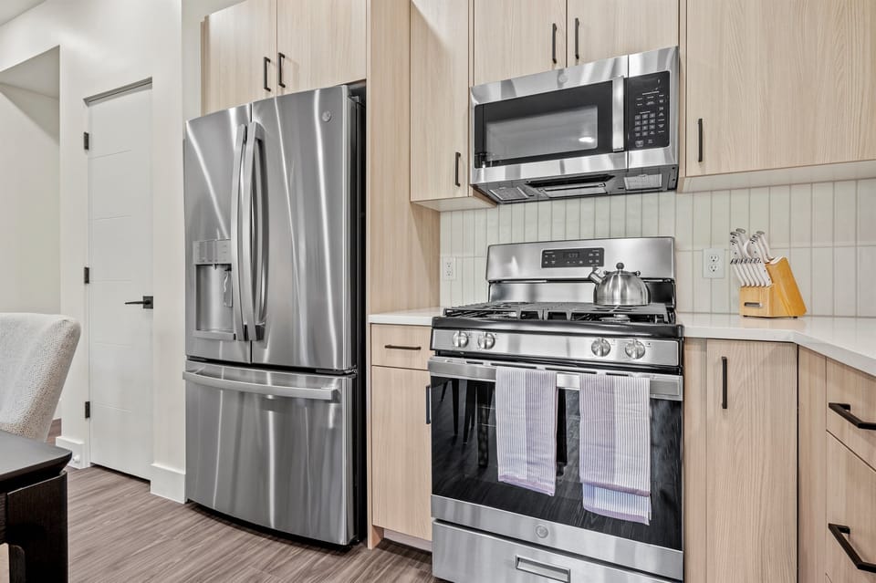 This well-equipped kitchen features a gas stove, fridge with ice maker, microwave, and other appliances for your convenience and culinary enjoyment.