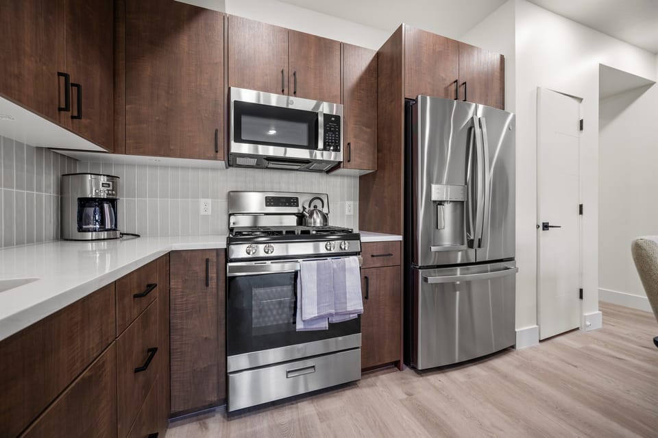 This well-equipped kitchen features a gas stove, fridge with ice maker, microwave, and other appliances for your convenience and culinary enjoyment.
