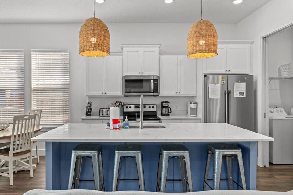 A lovely kitchen with a sleek island, featuring high chairs that create the perfect spot for casual meals and socializing.