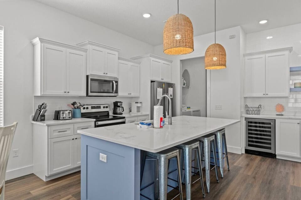 A lovely kitchen with a sleek island, featuring high chairs that create the perfect spot for casual meals and socializing.