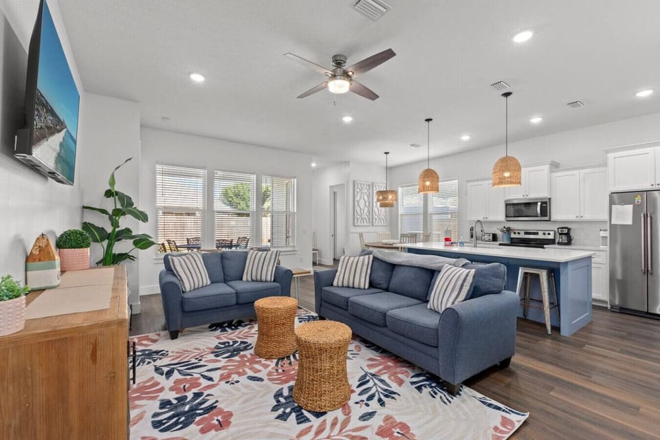 A bright, beach-themed open living room and kitchen, filled with natural light and coastal charm, creating the perfect relaxing retreat!