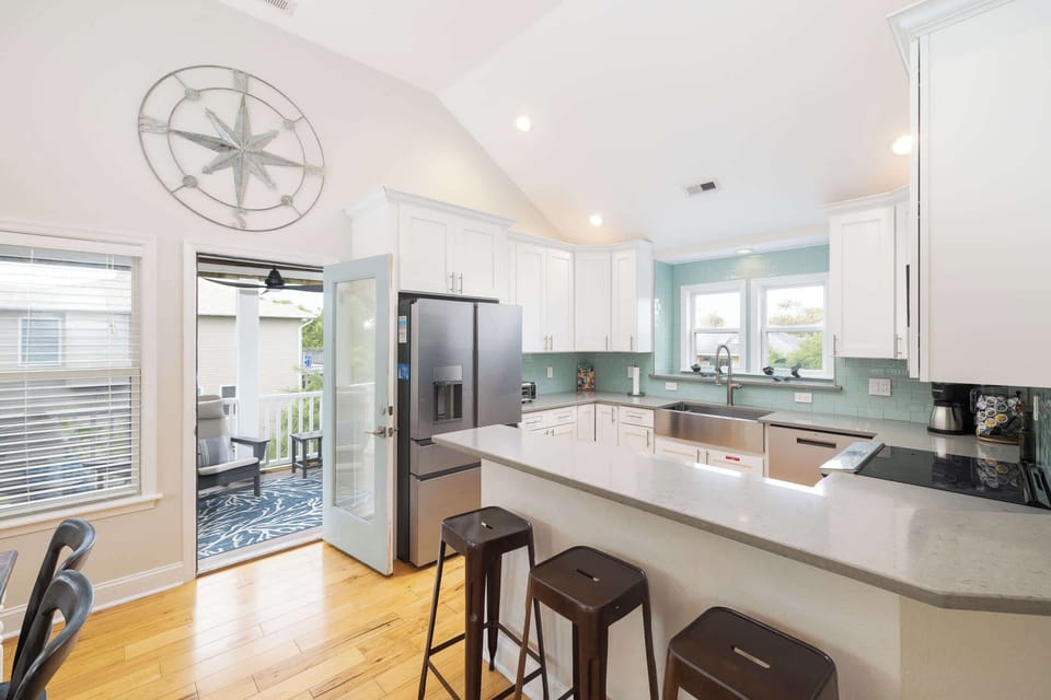Bright White Kitchen w Stainless Steel Refrigerator, Microwave, Oven Range, Dishwasher, Sink, Cooking Utensils and Quartz Counters with Breakfast Bar