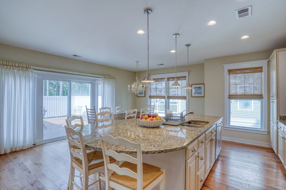 30220 Seaglass Way - Open Culinary & Social Space - Large sliding glass doors lead to the outdoor deck, flooding the kitchen and dining area with natural light. The seamless flow into the adjacent dining room makes this an ideal home for entertaining.