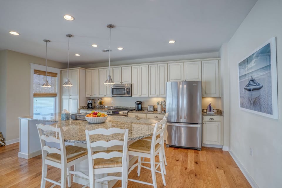 30220 Seaglass Way - Elegant Coastal Dining - Situated between the kitchen and the great room, the formal dining area features a large table with seating for eight. Surrounded by windows, it offers a bright and scenic setting for family meals and holiday gatherings.