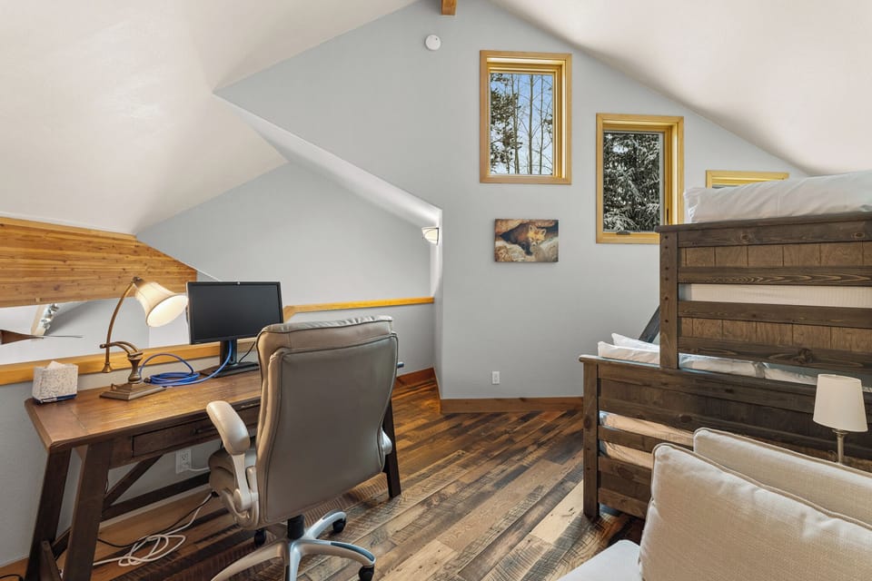 Upstairs loft with a twin over queen bunk bed, desk with monitor, walk-in closet, and en suite bathroom.