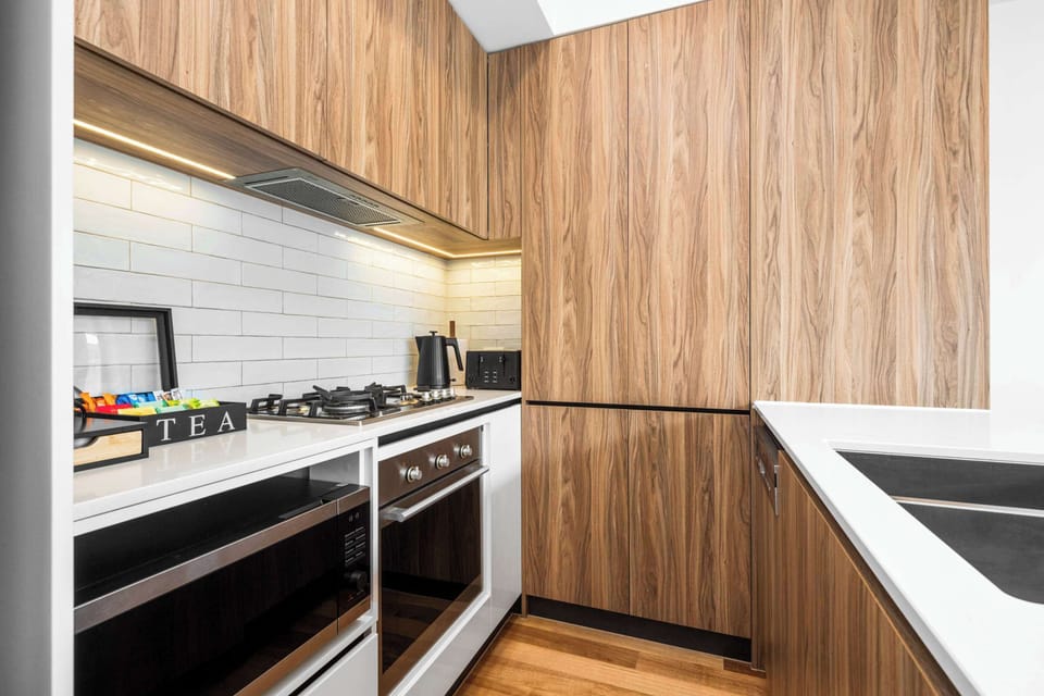 Fully equipped kitchen featuring stainless steel appliances including dishwasher, plus coffee pod machine. 