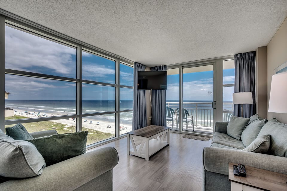 Corner-unit living room with floor-to-ceiling ocean views