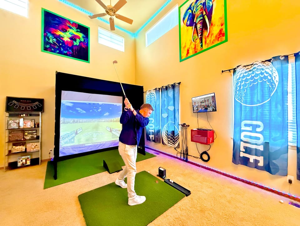 Expansive indoor golf simulator area with a basketball hoop, offering fun and versatility for all your favorite activities