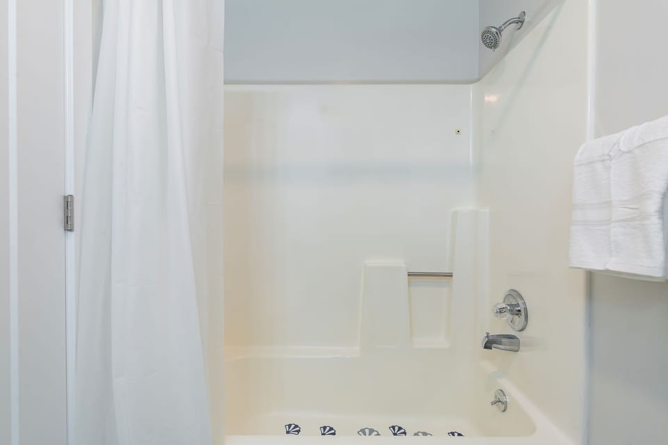 The bathroom is designed for comfort and function.
Tiled shower, plush towels, and thoughtful touches.