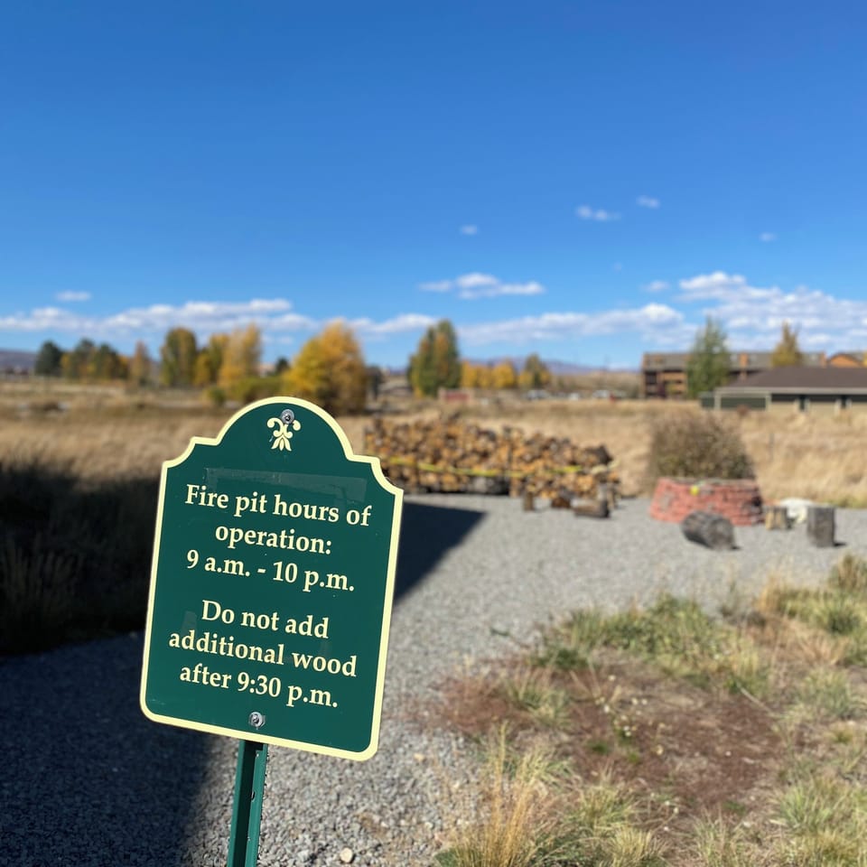 Fire pit area with autumn foliage and clear blue skies providing a scenic outdoor gathering space.