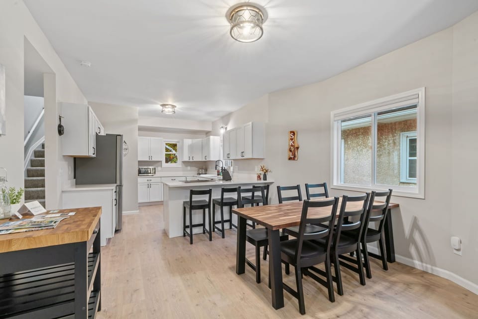 Gather around your spacious kitchen and dining area, where crisp white cabinets and warm wood flooring create the perfect backdrop for memorable meals together.