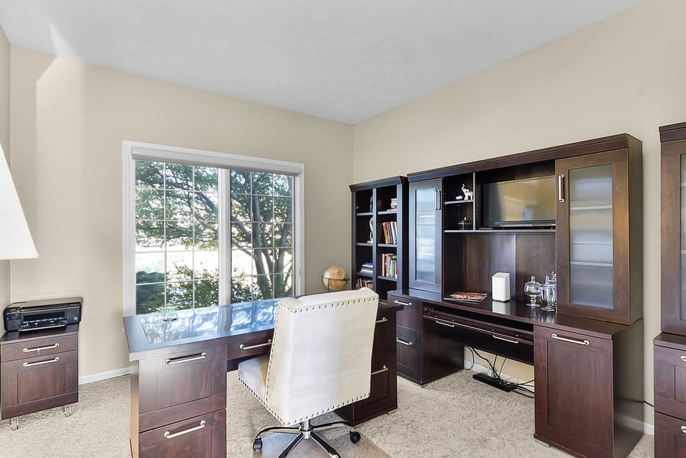 Your dedicated workspace features custom dark wood cabinetry, built-in storage, and peaceful garden views to inspire productivity.