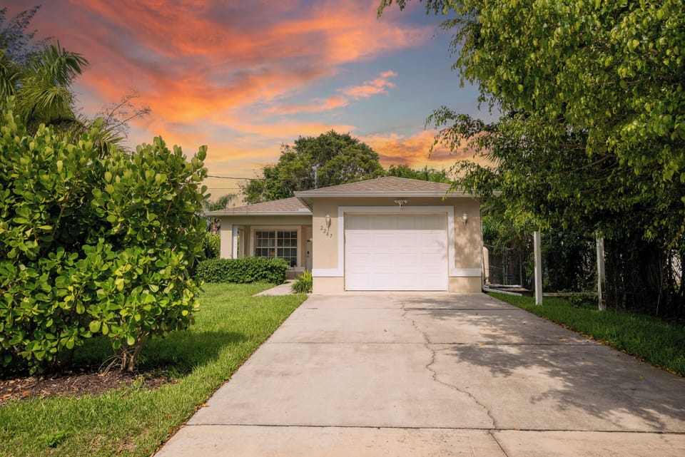 Front of the house. One car garage and long driveway.