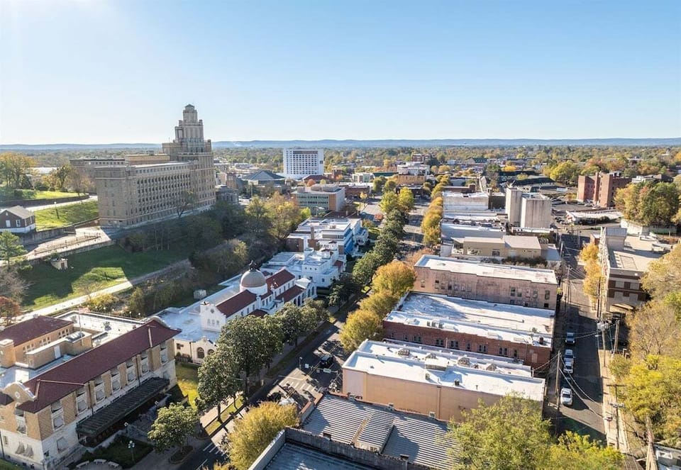 This aerial perspective captures the heart of downtown Hot Springs, showcasing its vibrant blend of historic landmarks, lush greenery, and local culture.