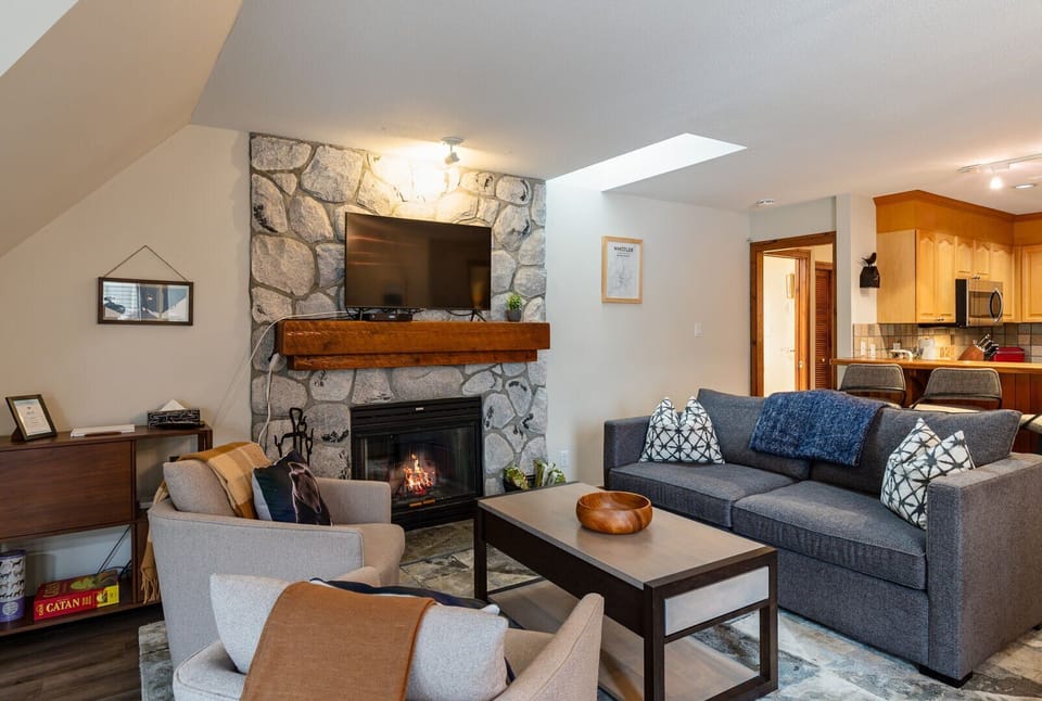 Cozy up in the inviting living room, complete with a wood-burning fireplace and plush seating.