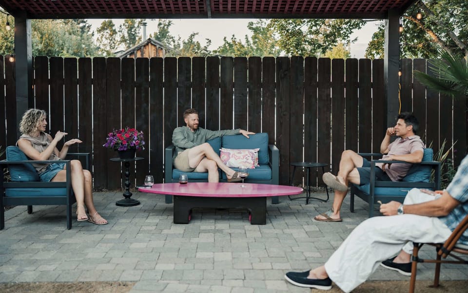 Covered outdoor lounge area with comfortable armchairs, ideal for relaxing group conversations.
