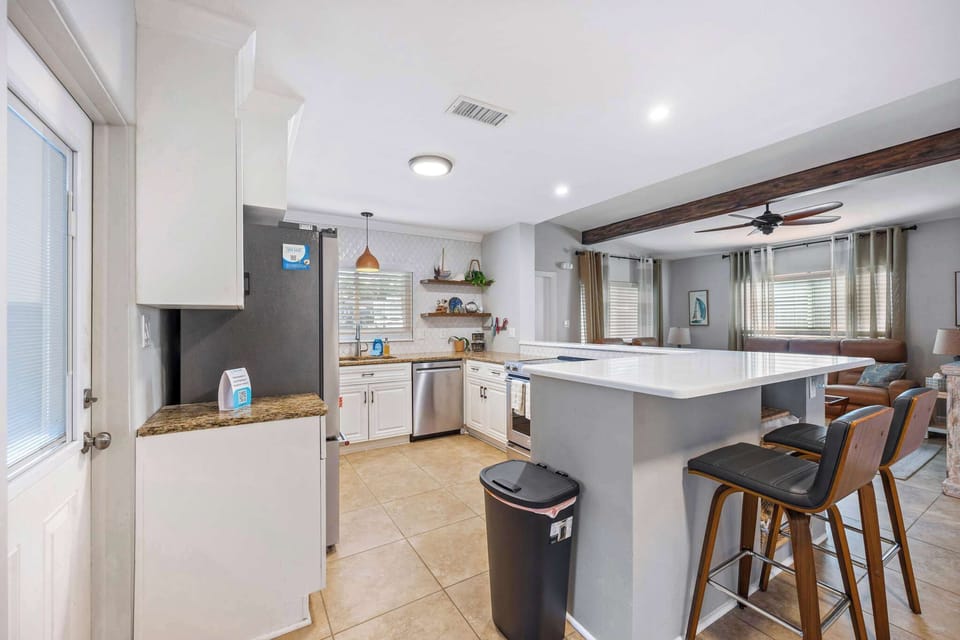 Open kitchen with a breakfast bar and modern appliances overlooking the living area.