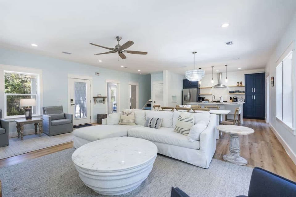 - Stylish open concept living area with a cloud soft sectional and elegant round tables - Light filled layout connects effortlessly to the dining space and gourmet kitchen - Designed for laughter, lounging, shared meals, and memorable moments