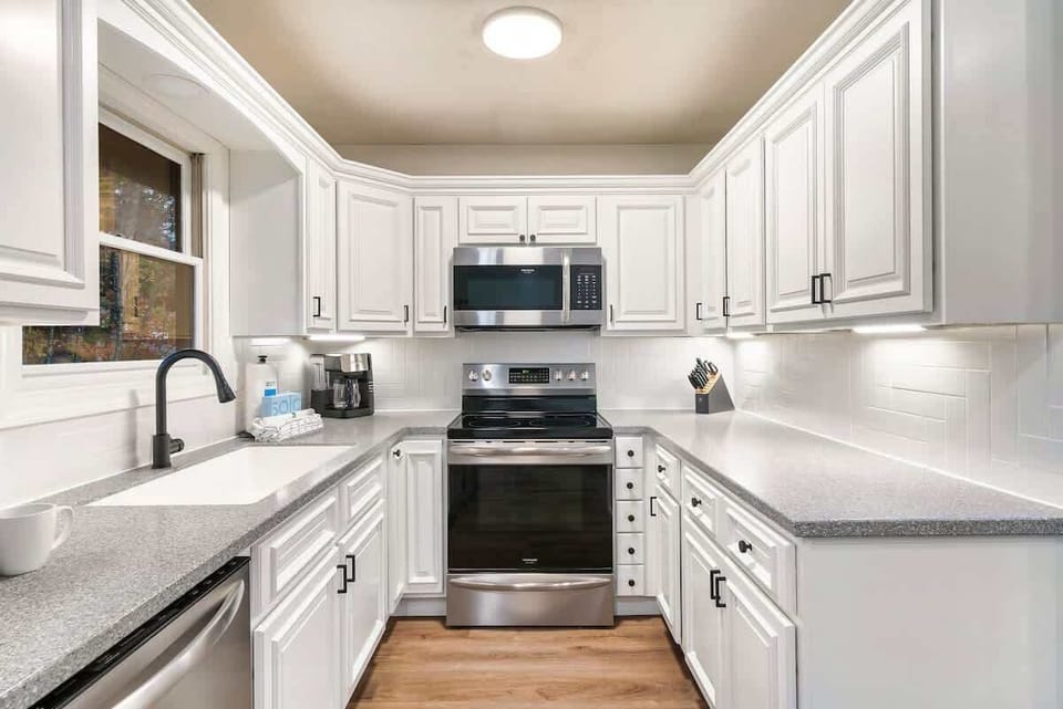 Modern kitchen with white cabinetry and stainless steel appliances