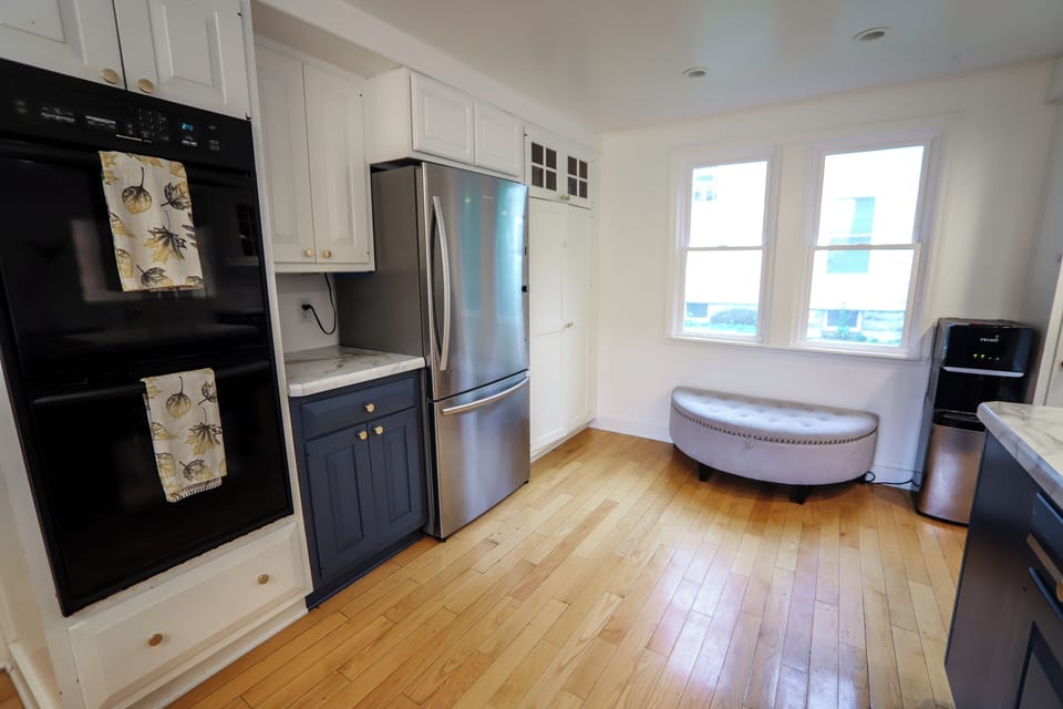 The cozy kitchen is bright and airy and has soft seating for cozy moments