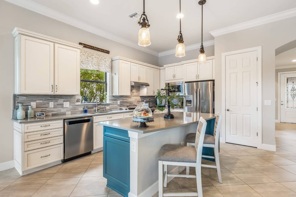 The beautiful open kitchen space is defined by an eating bar with a pair of barstools.