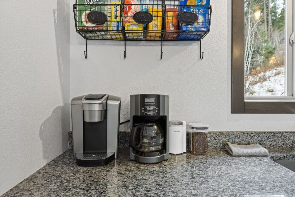The coffee corner of the kitchen is thoughtfully designed with a coffee maker, neatly organized storage for coffee supplies, and a cozy counter space perfect for brewing and enjoying a cup of coffee.
