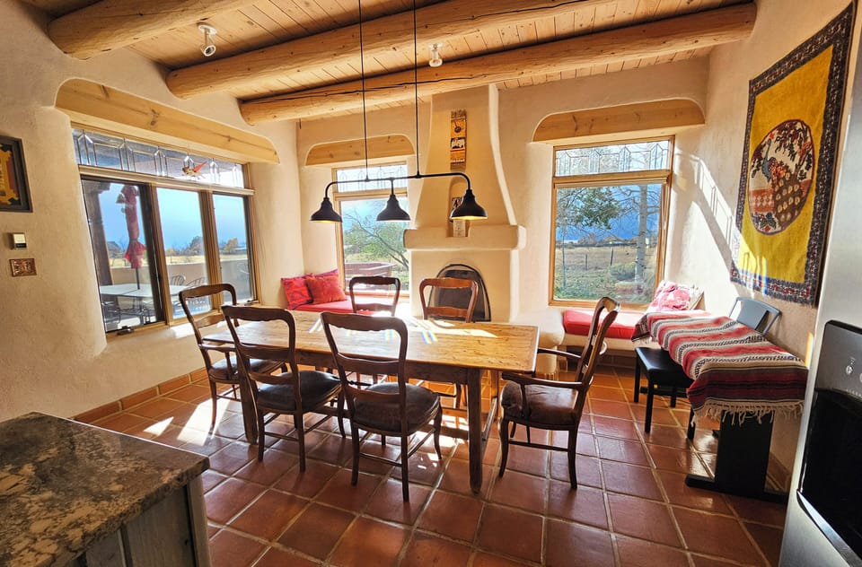 Dining area has a kiva fireplace and views of the back patio and western views.