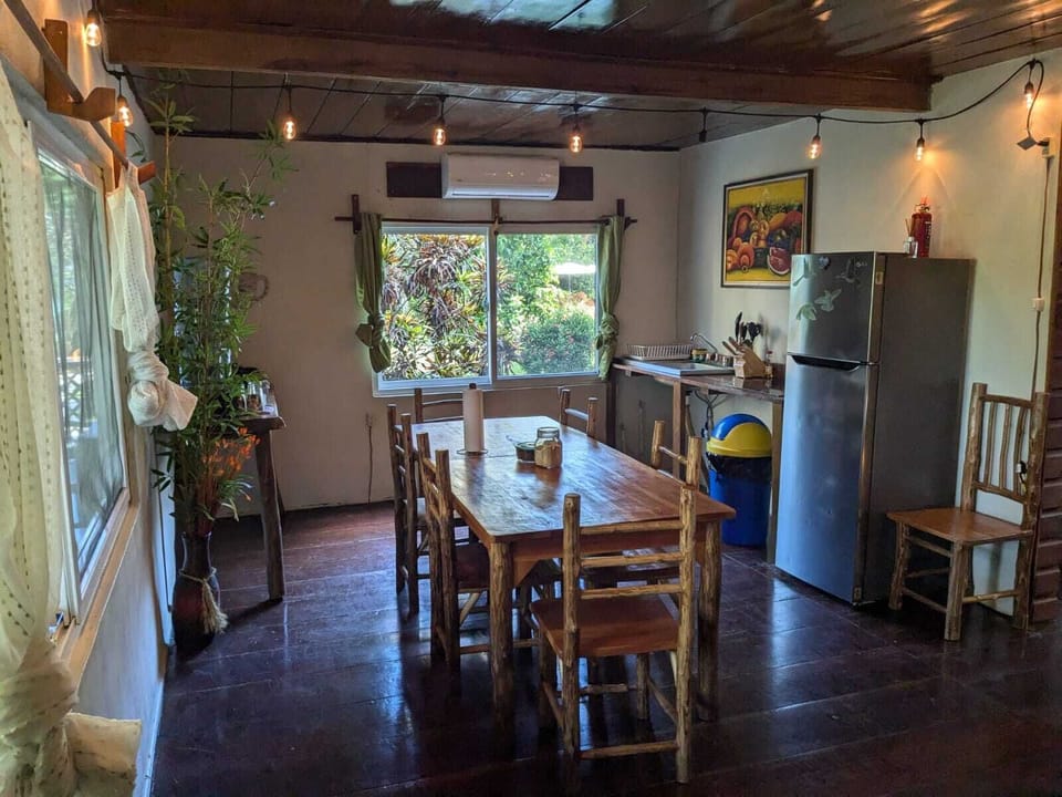 Our cozy cabin features a charming. Including a refrigerator, stove, coffe pot, preparing meals feels like a breeze. Also has water to drink, some plates, cups, glass. Of course has Air conditioning. And Wooden table to enjoy your meal.